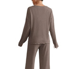 Femme portant un ensemble lounge en tricot côtelé marron, pull à manches longues et pantalon assorti, mode confortable et élégante.