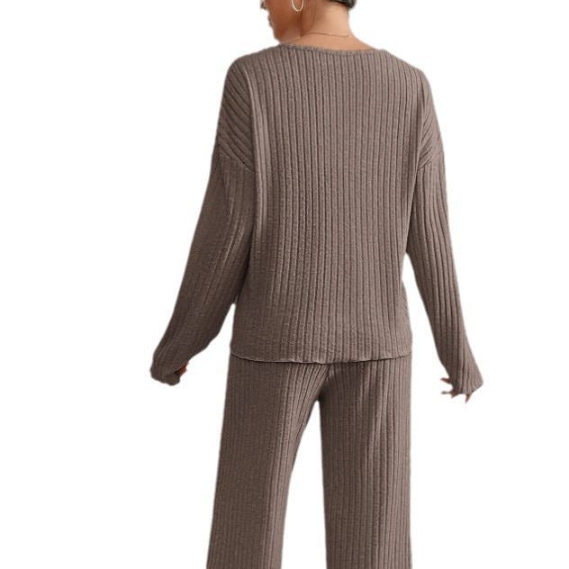 Femme portant un ensemble lounge en tricot côtelé marron, pull à manches longues et pantalon assorti, mode confortable et élégante.