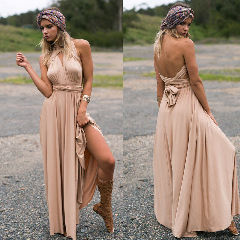 Femme en robe longue beige élégante, pose en extérieur. Robe dos nu, fendue, accessoirisée d'un bandeau et bottes hautes. Mode bohème chic.