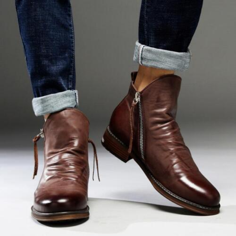 Bottes en cuir marron pour homme avec fermeture éclair, portées avec un jean retroussé. Chaussures élégantes et tendance pour l'automne.