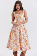 Robe d'été fleurie femme, coupe évasée, bretelles larges, fond blanc avec motifs floraux roses et oranges, style décontracté chic.