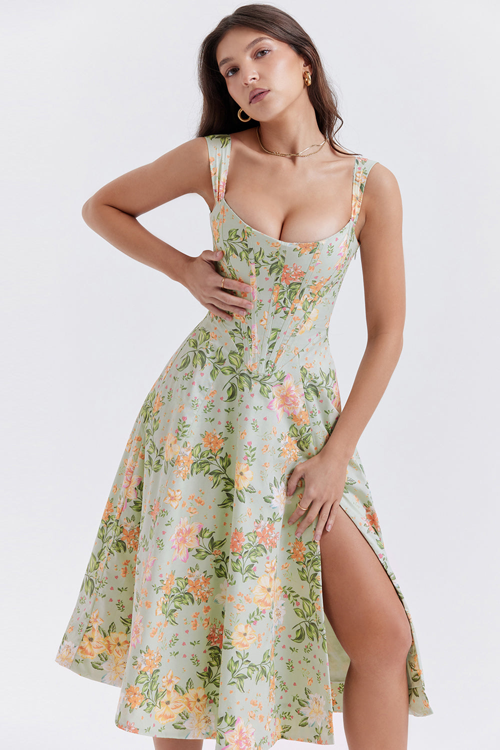Robe longue à fleurs vertes avec fente, portée par une femme. Style élégant et estival, idéal pour les occasions spéciales et les sorties estivales.
