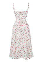 Robe d'été blanche à motifs floraux roses, bretelles fines, taille cintrée, style vintage. Mode féminine, élégante et décontractée.