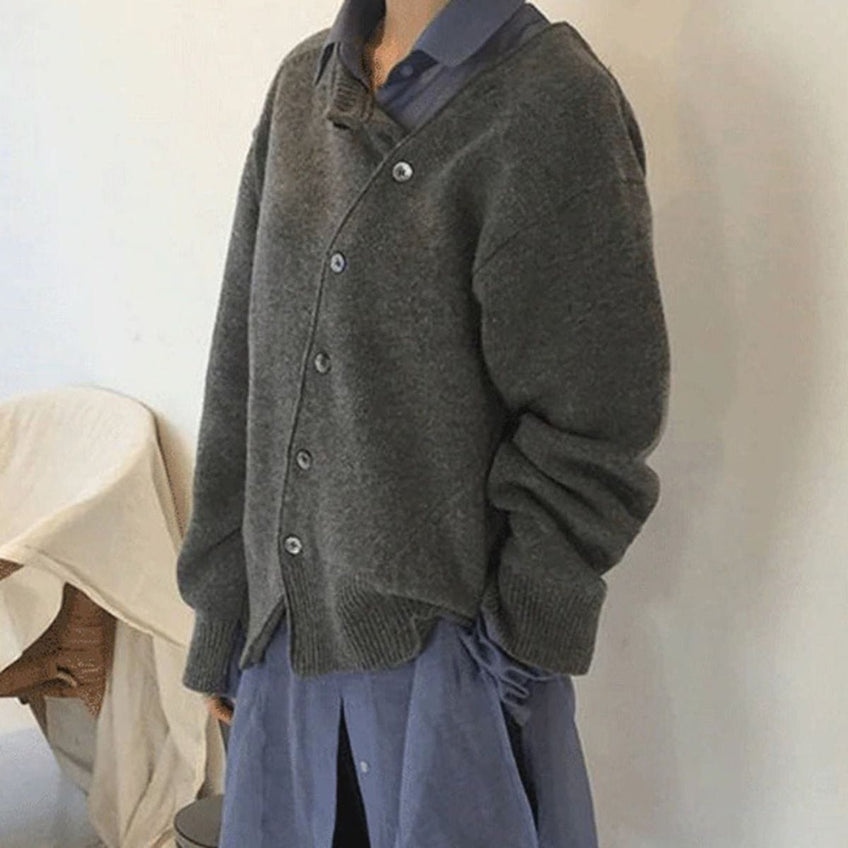 Femme portant un cardigan gris en laine sur une chemise bleue, style décontracté et élégant, mode automne-hiver, vêtements confortables.