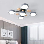 Plafonnier moderne à LED avec design circulaire noir et bois, installé dans une chambre élégante avec murs gris et rideaux bleus.