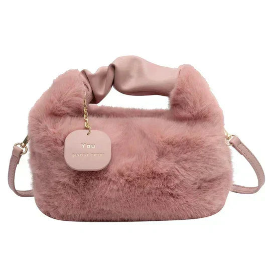 Sac à main rose en fausse fourrure avec anse souple, étiquette dorée "Y Dou", design élégant et moderne, accessoire mode tendance.