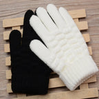 Deux gants en laine, un noir et un blanc, posés sur une surface en bois. Accessoires d'hiver, confortables et chauds, parfaits pour le froid.