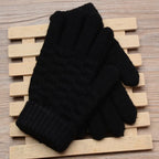 Gants noirs en laine posés sur un support en bois, parfaits pour l'hiver. Accessoire chaud et élégant pour hommes et femmes.