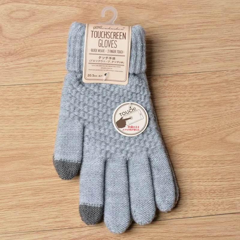 Gants tactiles gris en tricot, étiquette en anglais, sur fond de bois clair. Accessoire hiver, compatible écrans, style moderne et pratique.