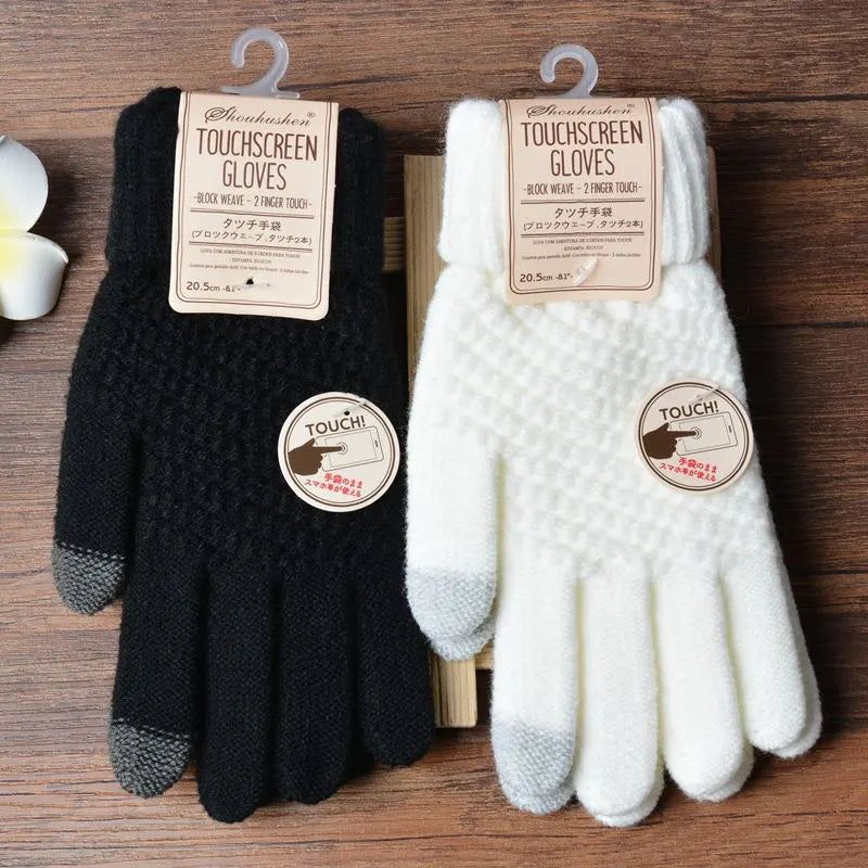 Gants tactiles noirs et blancs en laine, étiquetés, posés sur une table en bois. Accessoires d'hiver, compatibles écrans tactiles.