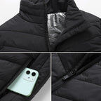 Veste matelassée noire avec doublure thermique argentée, poche zippée contenant un smartphone, fermeture éclair visible. Mode hiver, vêtements chauds.