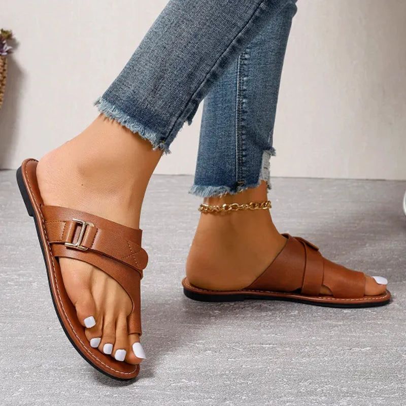 Sandales en cuir marron pour femme avec boucle, portées avec un jean décontracté. Chaussures d'été élégantes et confortables.