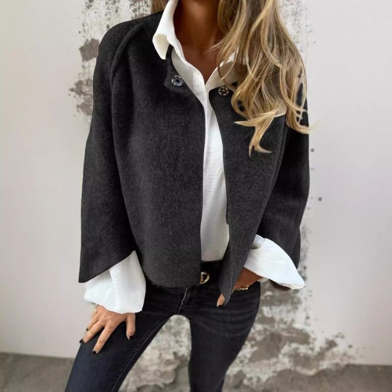Femme portant une veste noire élégante sur chemise blanche, jeans ajustés. Mode automne, style chic décontracté, tendance vestimentaire féminine.
