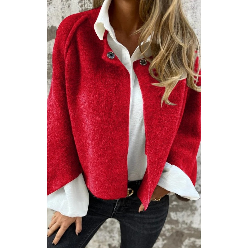 Femme portant un manteau rouge élégant sur une chemise blanche, avec un jean noir. Mode automne, style chic et décontracté.