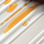 Gouttes de miel doré sur une surface texturée blanche, capturant la douceur et la brillance du liquide sucré.