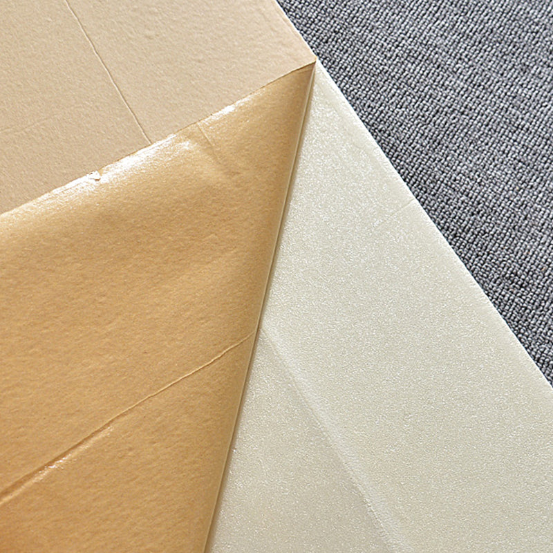Papier transfert textile sur fond gris, montrant une feuille marron et une feuille blanche brillante. Accessoire essentiel pour impression sur tissu.