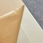Papier sulfurisé brun et feuille de cuisson antiadhésive blanche sur fond de tissu gris. Accessoires de cuisine essentiels pour pâtisserie.