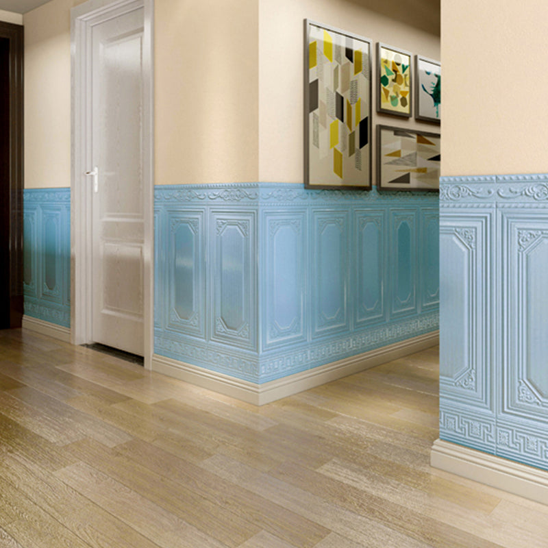 Couloir intérieur avec lambris bleu, sol en bois clair, porte blanche et tableaux modernes. Décoration murale élégante et contemporaine.