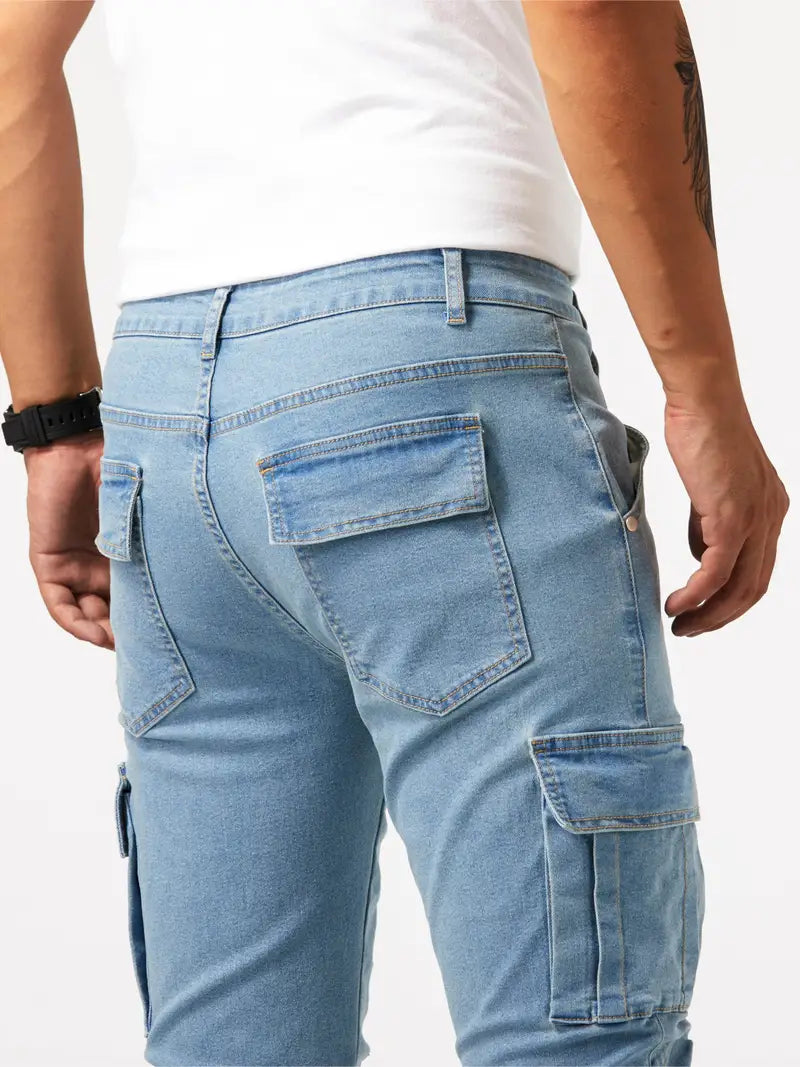 Homme portant un jean cargo bleu clair avec poches multiples, montre noire au poignet, sur fond blanc. Mode masculine décontractée.