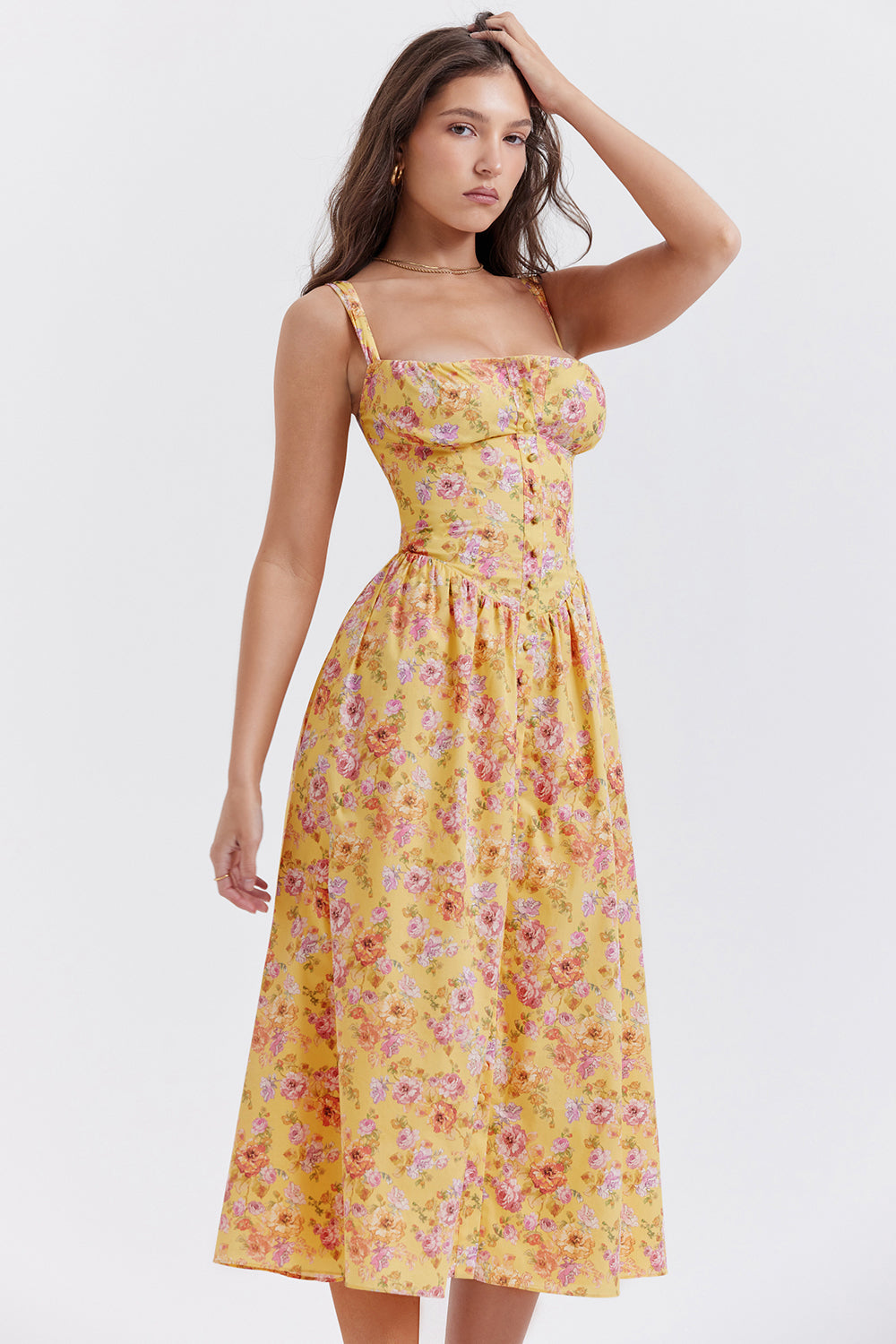 Robe longue jaune à fleurs roses portée par une femme, style été, bretelles fines, coupe ajustée, mode féminine élégante et tendance.