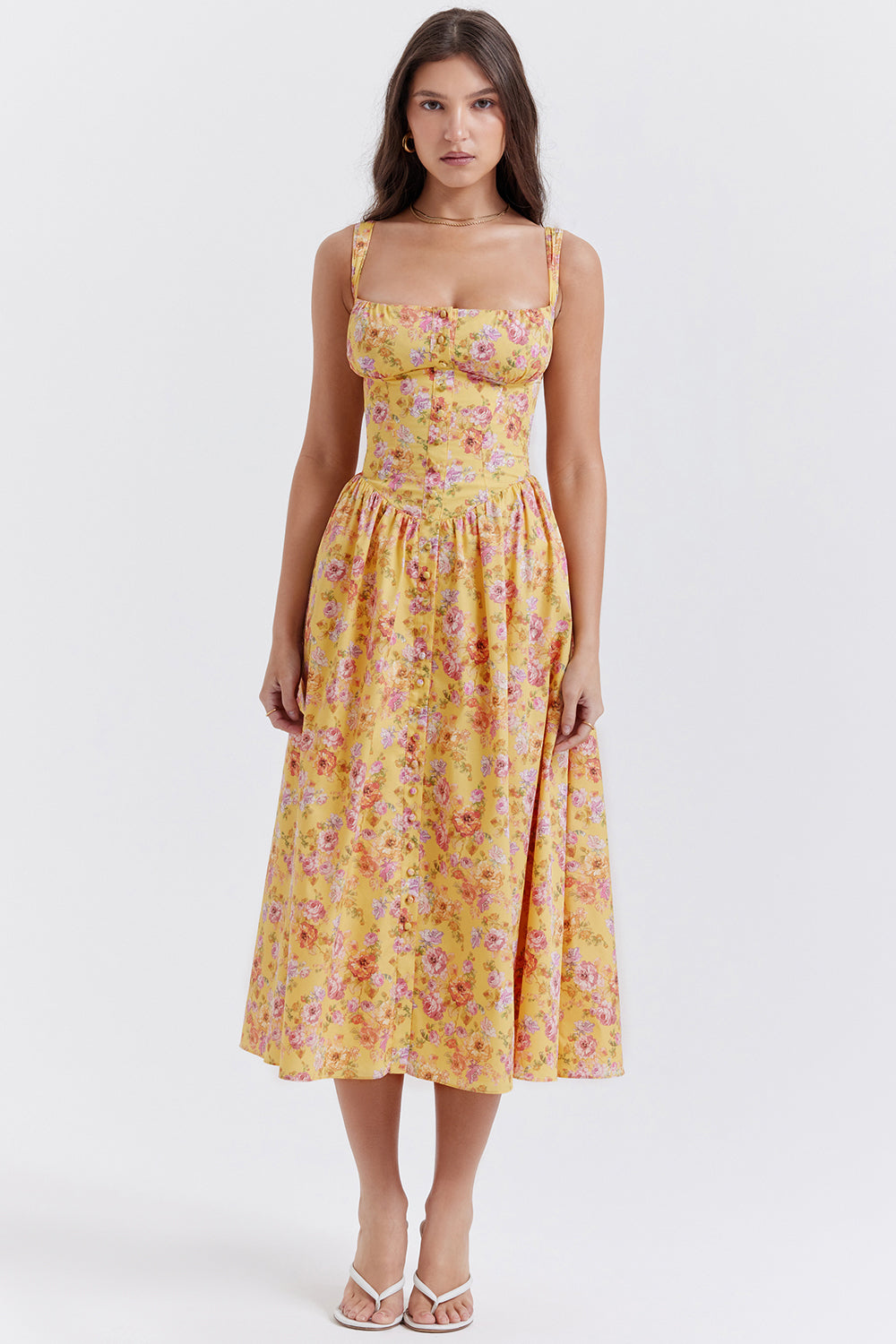 Robe longue jaune à fleurs portée par une femme, style été, bretelles larges, coupe ajustée, idéale pour mode féminine et tendance estivale.