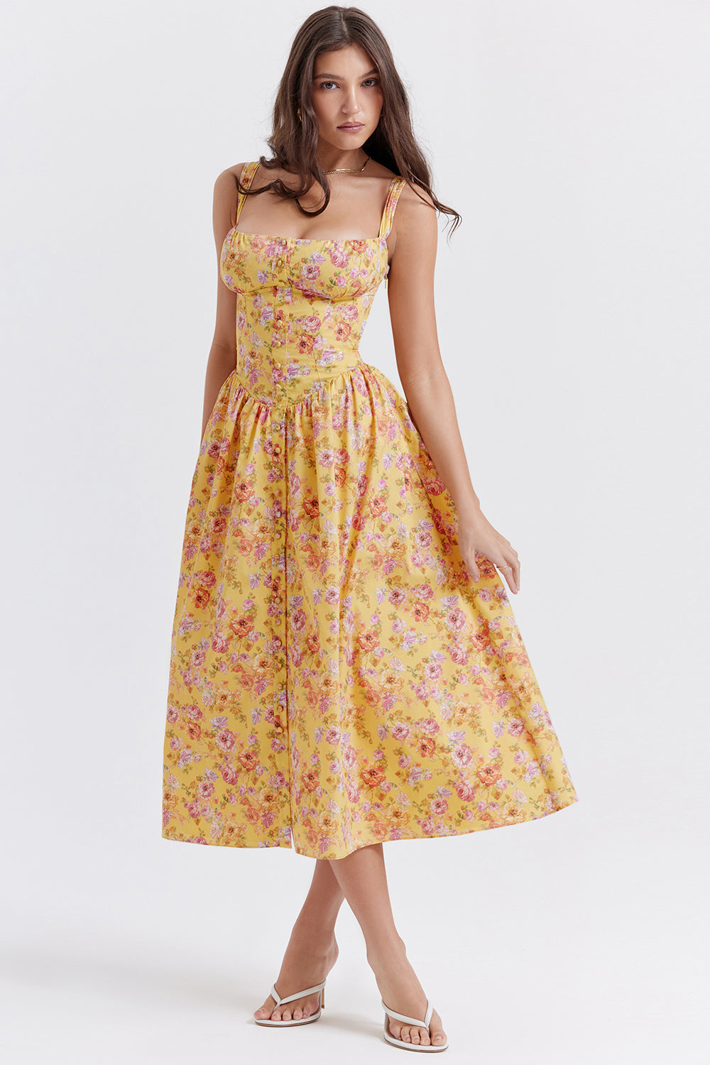Robe longue jaune à fleurs portée par une femme, style été, bretelles fines, coupe ajustée, idéale pour mode féminine, tendance et élégante.