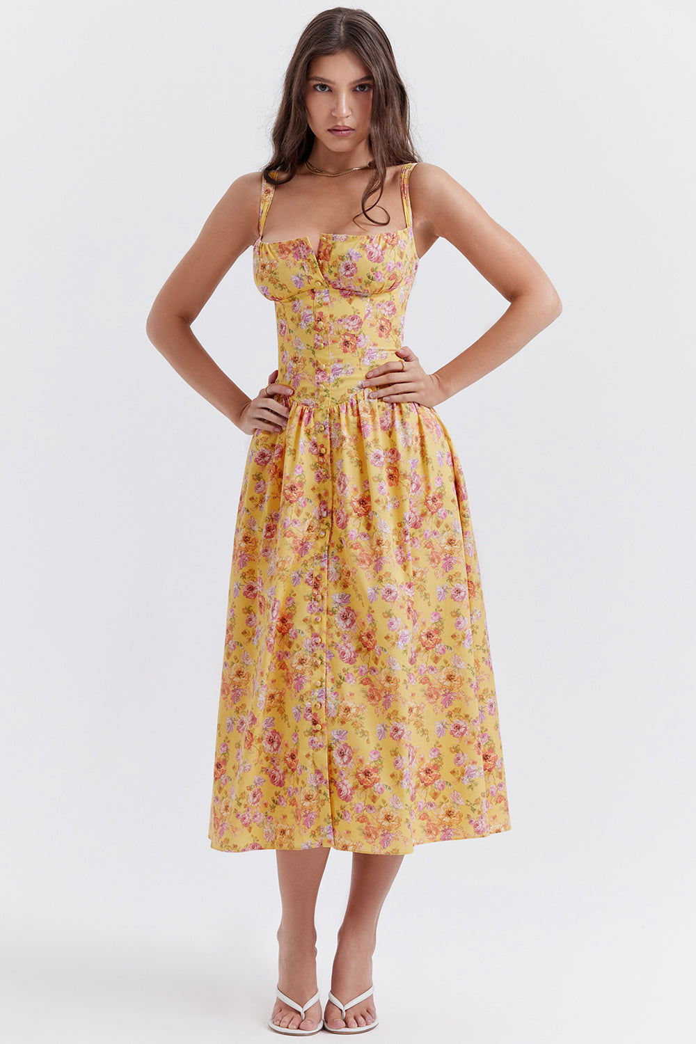 Robe longue jaune à fleurs roses, bretelles fines, corsage ajusté, jupe évasée. Mode féminine élégante, tendance été, style vintage.