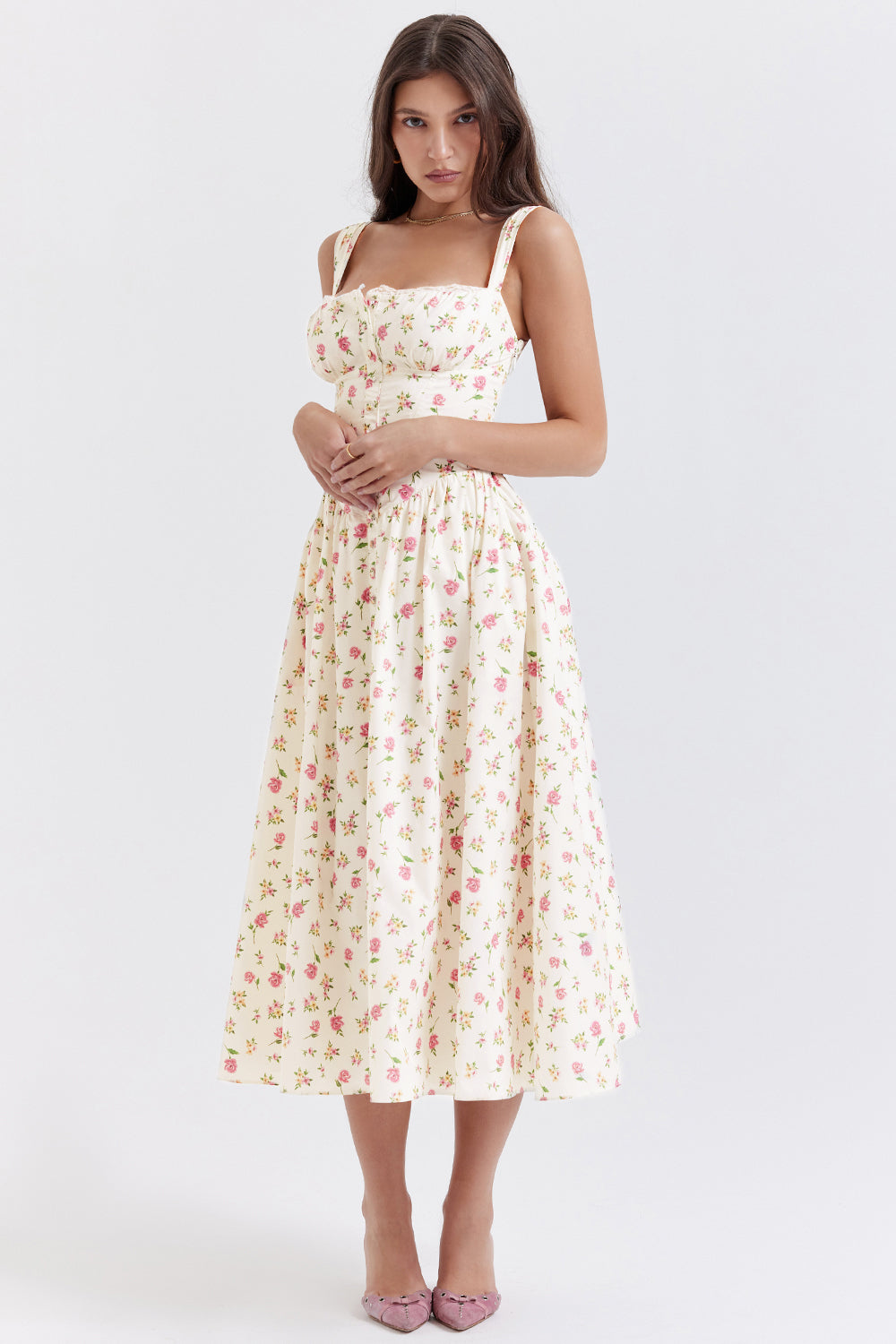 Robe longue à fleurs blanches et roses, style vintage, portée par une femme. Mode féminine élégante, idéale pour l'été et les occasions spéciales.