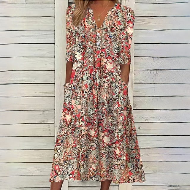 Robe longue bohème à motifs floraux colorés, manches mi-longues, fond en bois blanc. Mode féminine estivale, style décontracté et élégant.