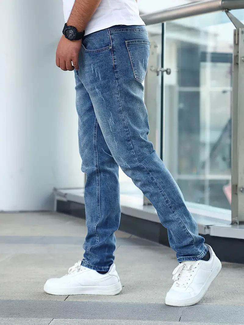 Jeans homme décontractés en denim bleu, coupe droite, avec baskets blanches modernes. Mode masculine urbaine, style tendance et confortable.