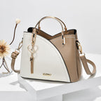 Sac à main en cuir bicolore beige et blanc avec poignée dorée, pendentif cœur, design élégant. Accessoire mode femme tendance.