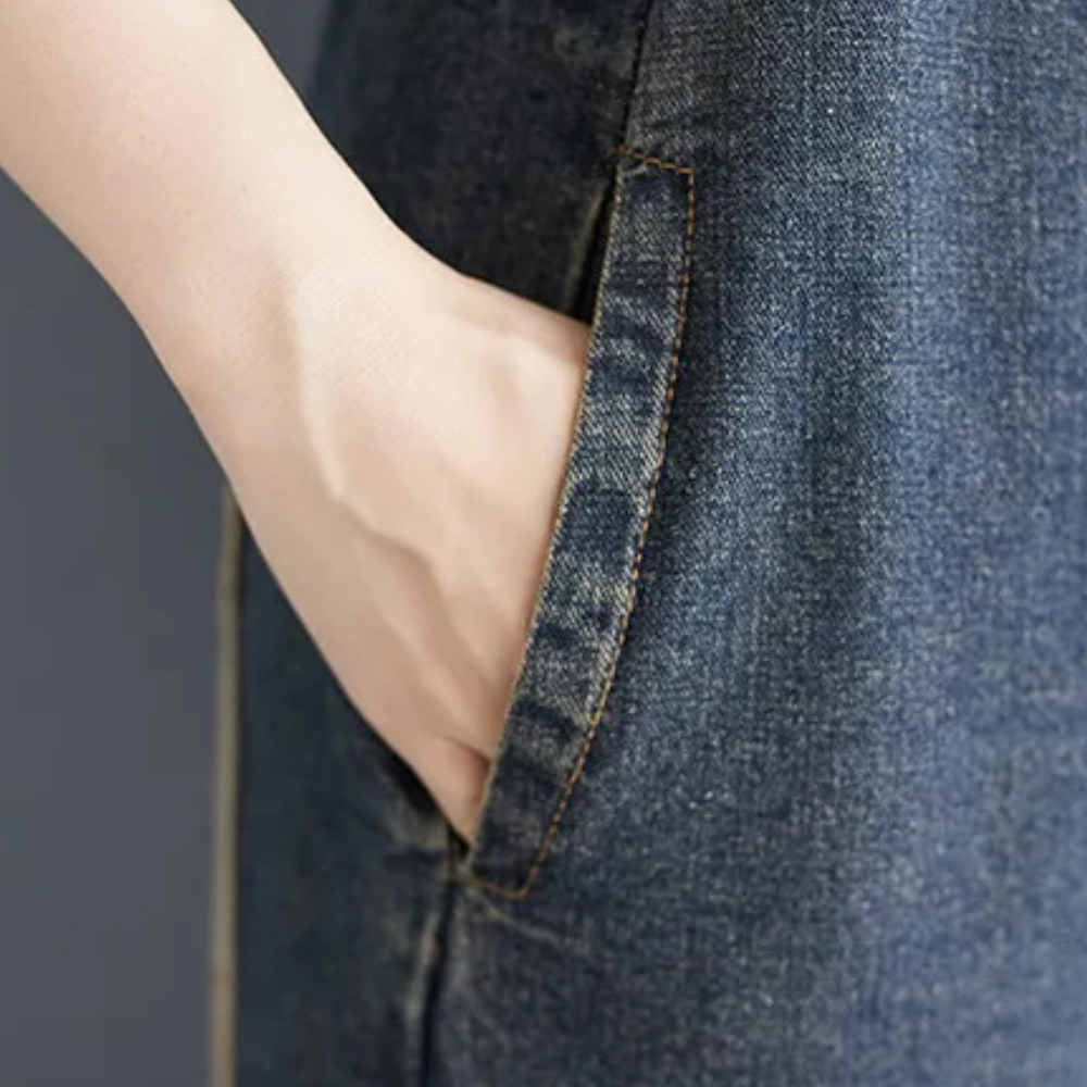 Main dans la poche d'un jean bleu foncé, gros plan. Mode décontractée, tissu denim, style moderne. Idéal pour vêtements casual et tendances.