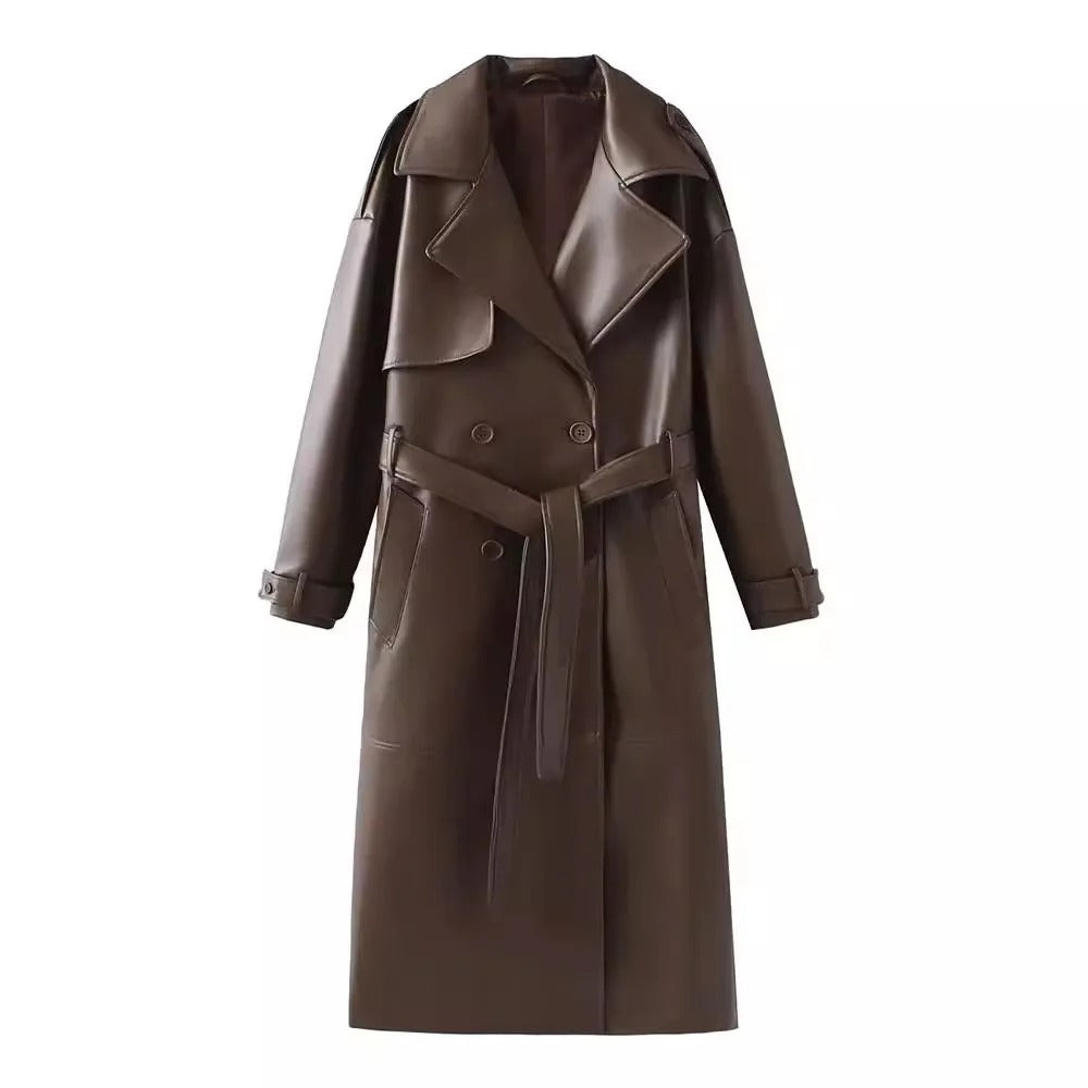 Manteau long en cuir marron, style trench-coat, avec ceinture, col large et boutons, mode automne-hiver, élégant et tendance.
