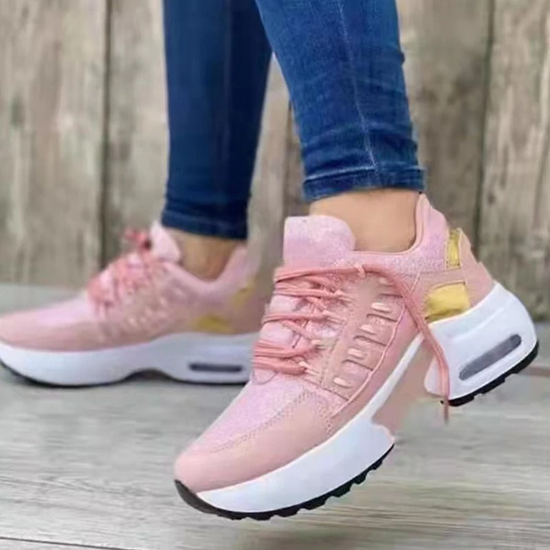 Baskets roses pour femme avec semelle épaisse, portées avec un jean. Chaussures de sport tendance, confortables et modernes.