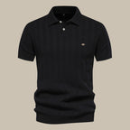 Polo noir élégant pour homme, manches courtes, col boutonné, motif discret, idéal pour un look chic et décontracté. Mode masculine tendance.