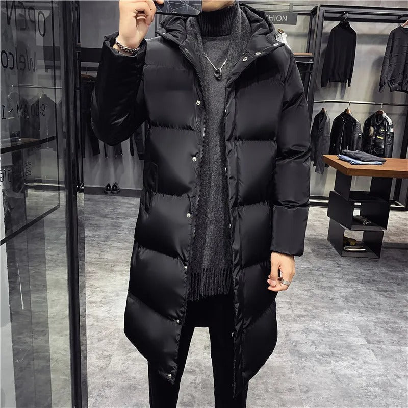 Homme portant un manteau long noir en duvet dans une boutique de vêtements moderne. Mode hiver, style élégant, tendance masculine.