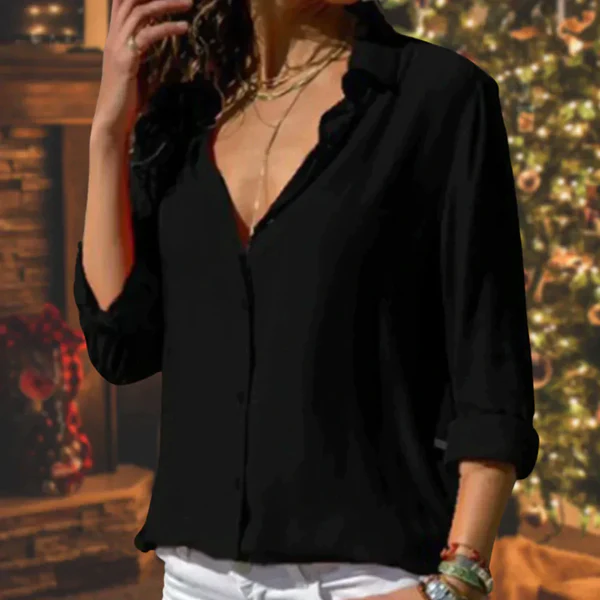 Femme portant une chemise noire élégante devant un sapin de Noël décoré, ambiance festive, mode automne-hiver, style chic et décontracté.