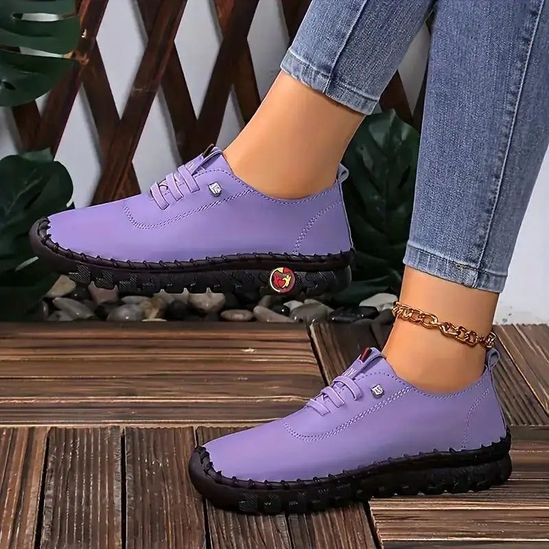 Chaussures violettes pour femme avec semelle noire, portées avec un jean. Design moderne et confortable, idéal pour la mode urbaine.