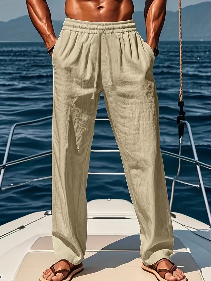 Homme en pantalon beige sur un yacht, mer en arrière-plan. Mode estivale, style décontracté, vacances en bateau, tenue légère pour homme.