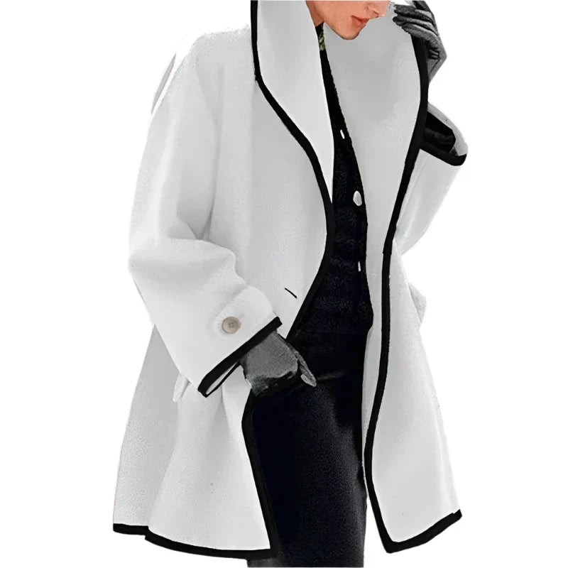 Manteau blanc élégant avec bordures noires, porté par une personne en tenue noire. Mode hiver chic, style moderne et sophistiqué.