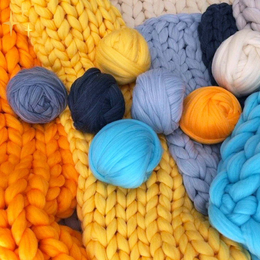 Pelotes de laine colorées sur tricot épais, tons jaune, bleu, orange. Accessoires de tricot, fil doux, artisanat, décoration intérieure.