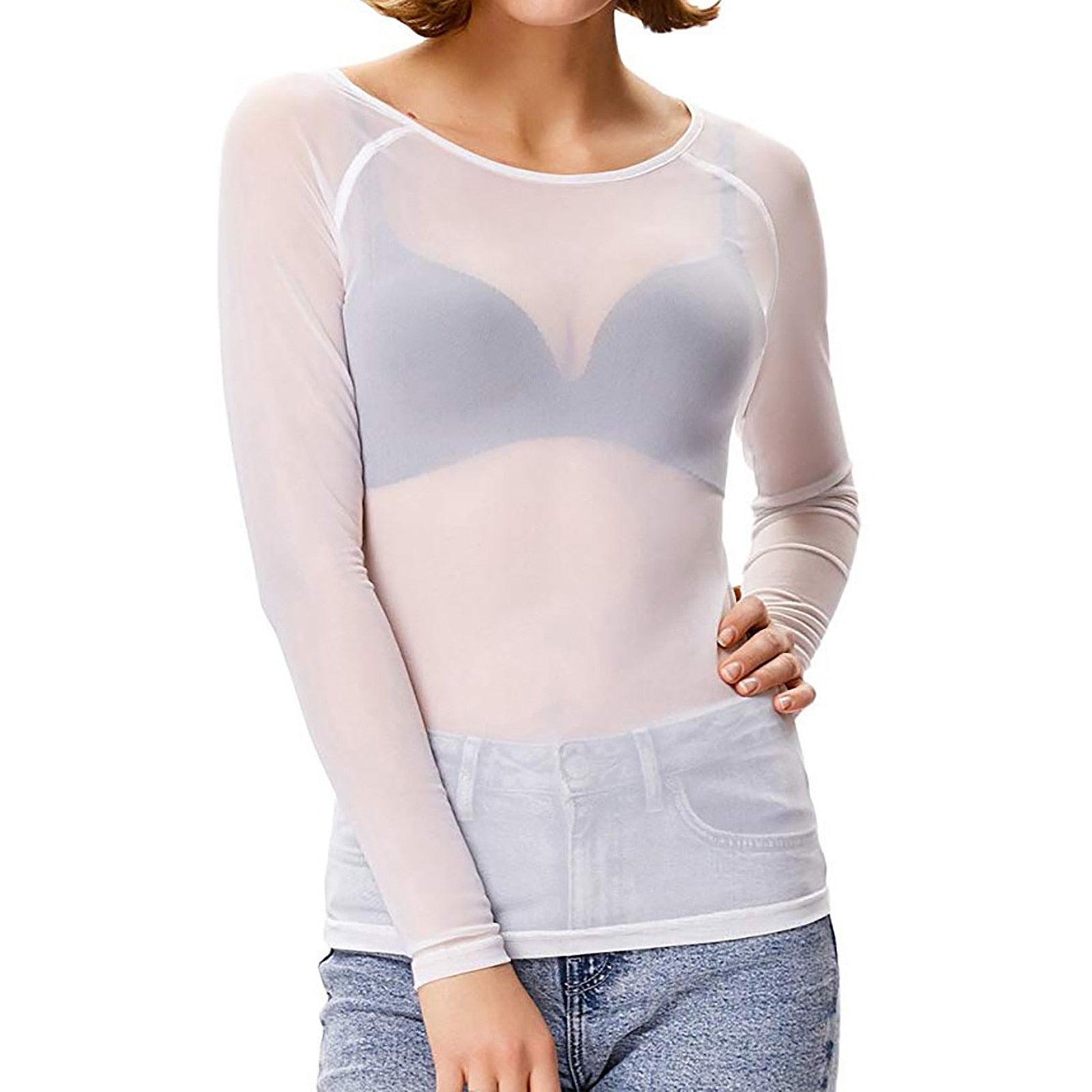 Femme portant un haut transparent blanc à manches longues, avec soutien-gorge visible, associé à un jean bleu. Mode féminine moderne et élégante.