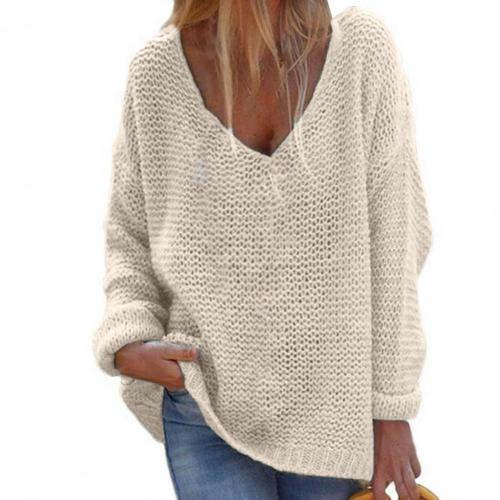 Femme portant un pull en maille beige oversize avec col en V, manches longues, style décontracté, mode automne-hiver, tenue confortable et élégante.