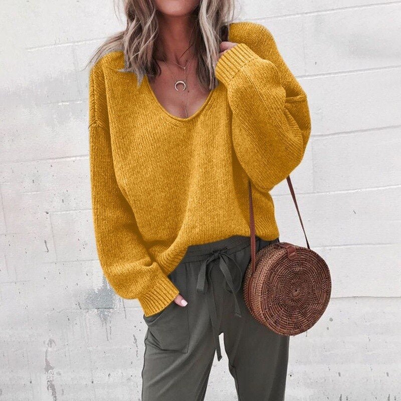 Femme portant un pull jaune moutarde ample, pantalon vert olive, et sac rond en osier. Mode automne, style décontracté, tendance féminine.