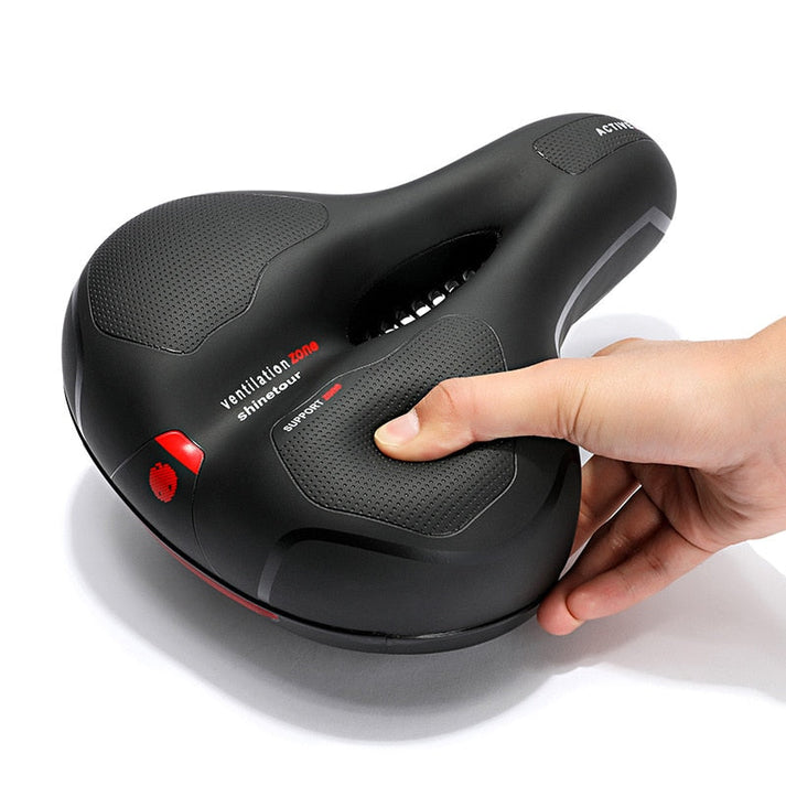Selle de vélo ergonomique noire avec zone de ventilation, design antidérapant, main appuyant pour montrer le confort. Accessoire cyclisme confortable.