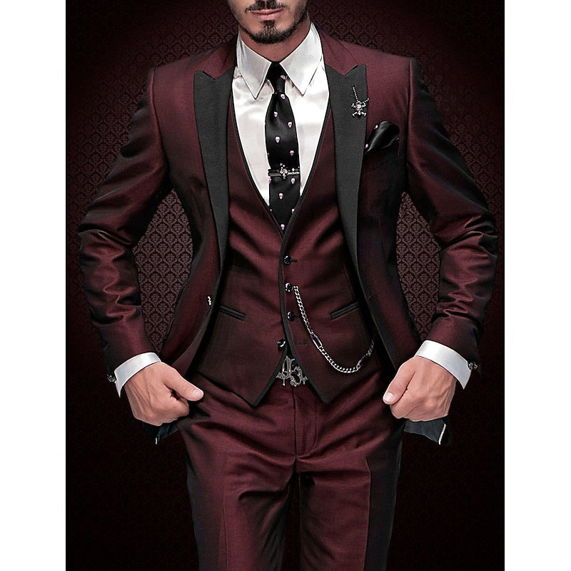 Homme en costume trois pièces bordeaux élégant, cravate noire à motifs, fond texturé sombre. Mode masculine, tenue formelle, style sophistiqué.