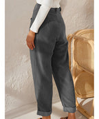 Pantalon en velours côtelé gris pour femme, style décontracté, taille haute, avec ourlets retroussés, associé à un pull blanc.
